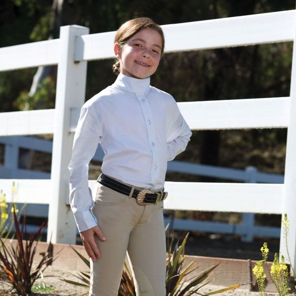 a child wearing a white riding shirt and tan pants